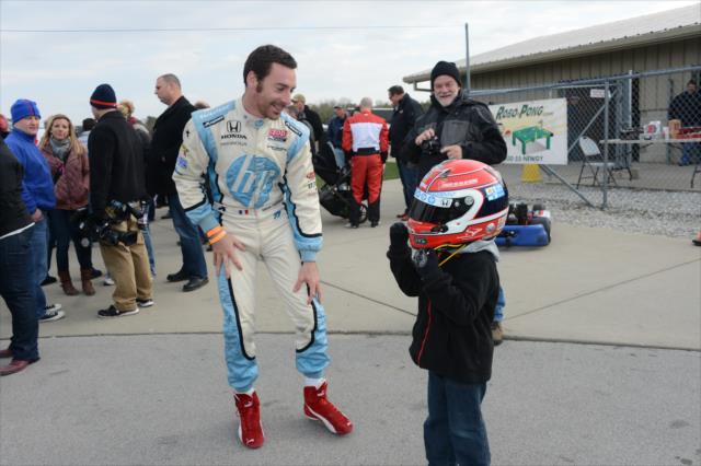 Simon Pagenaud lets a young fan try on his helmet at the Dan Wheldon Pro-Am Karting Classic -- Photo by: Chris Owens