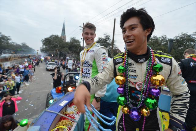 Sage Karam and Neil Aberico toss beads to the Mardi Gras crowd during the Krewe of Bacchus parade in New Orleans -- Photo by: Chris Owens
