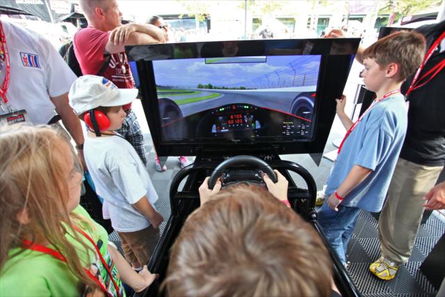Fans interacting with the racing simulator in the Fan Village -- Photo by: Shawn Gritzmacher