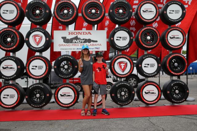 A couple of young fans pose for a photograph in the Firestone Fan Village at Barber Motorsports Park -- Photo by: Chris Jones