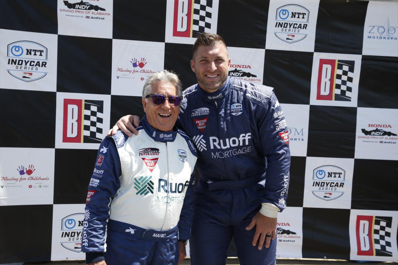 Tim Tebow with Mario Andretti prior to riding in the Ruoff Fastest Seat in Sports - Honda Indy Grand Prix of Alabama - By: Chris Jones -- Photo by: Chris Jones