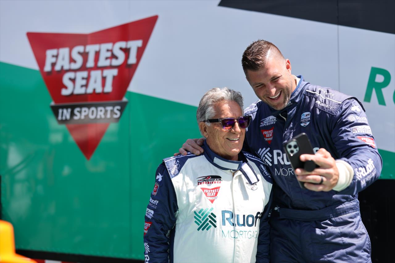 Tim Tebow with Mario Andretti prior to riding in the Ruoff Fastest Seat in Sports - Honda Indy Grand Prix of Alabama - By: Joe Skibinski -- Photo by: Joe Skibinski