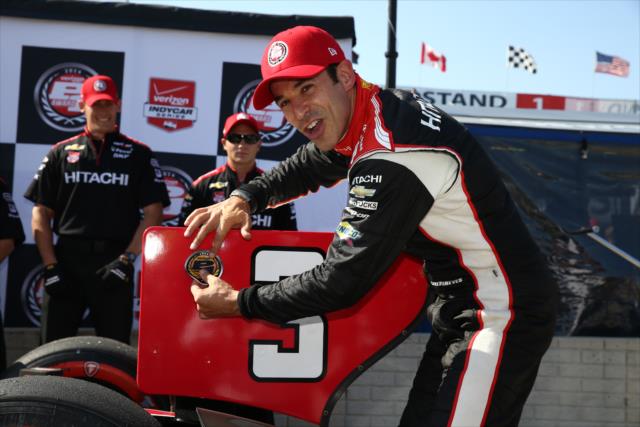 Helio Castroneves affixes the Verizon P1 Award emblem for winning the pole for Race 1 of the Chevrolet Indy Dual in Detroit -- Photo by: Chris Jones