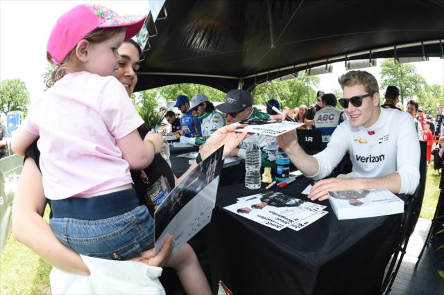 Josef Newgarden signs an autograph for a young fan during the autograph session at Belle Isle Park in Detroit -- Photo by: Chris Owens