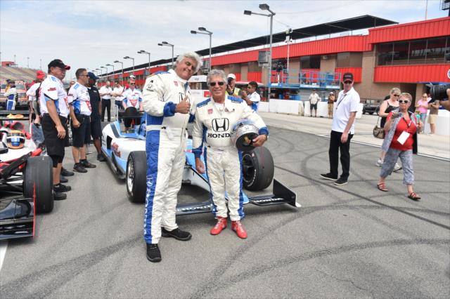 Jay Leno and Mario Andretti pose for a photo following their two-seater ride at Auto Club Speedway -- Photo by: Chris Owens