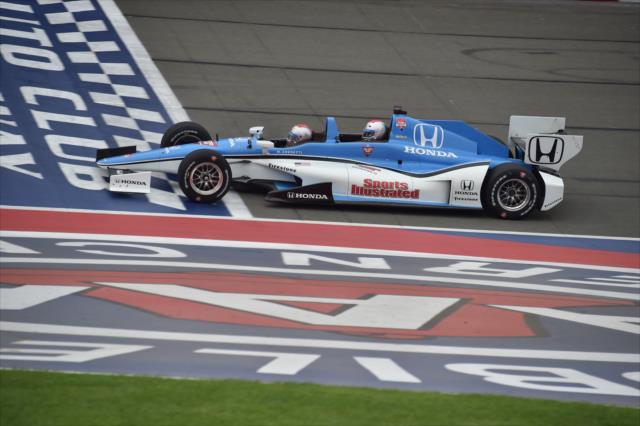 Jay Leno and Mario Andretti cross the start/finish line in the two-seater at Auto Club Speedway -- Photo by: Chris Owens