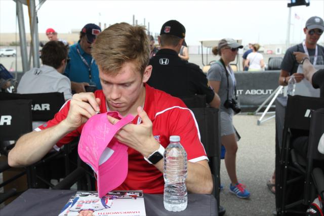 Jack Hawksworth signs an autograph hat during the autograph session in the INDYCAR Fan Village at Auto Club Speedway -- Photo by: Richard Dowdy
