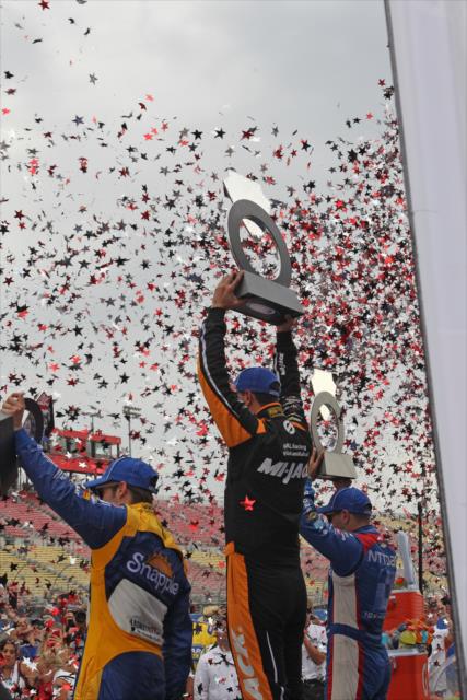 The podium of Graham Rahal, Tony Kanaan, and Marco Andretti hoist their trophies on Victory Lane following the MAVTV 500 at Auto Club Speedway -- Photo by: Richard Dowdy