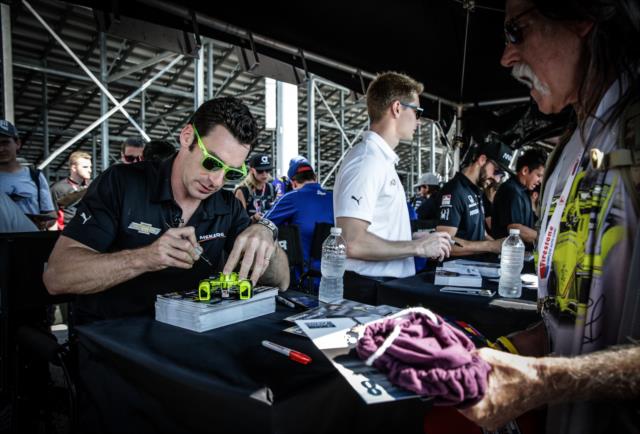 Simon Pagenaud signs an autograph during the autograph session in the INDYCAR Fan Village at Gateway Motorsports Park -- Photo by: Shawn Gritzmacher