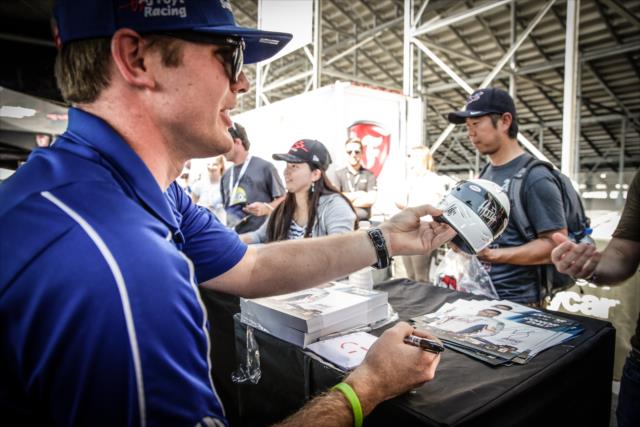 Conor Daly signs an autograph during the autograph session in the INDYCAR Fan Village at Gateway Motorsports Park -- Photo by: Shawn Gritzmacher