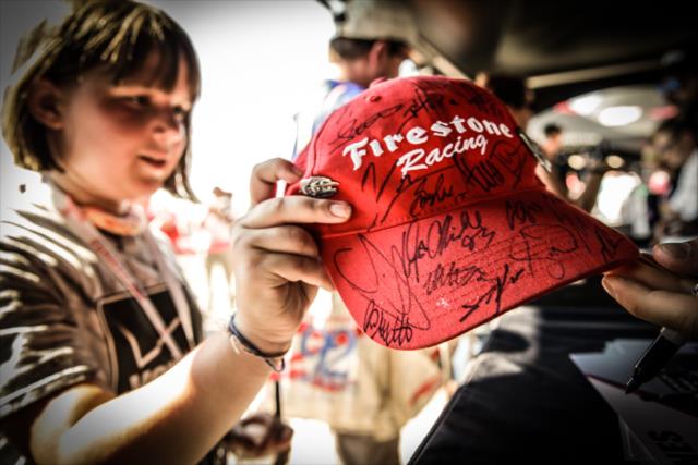 A young fan gets an autographed hat signed during the autograph session in the INDYCAR Fan Village at Gateway Motorsports Park -- Photo by: Shawn Gritzmacher