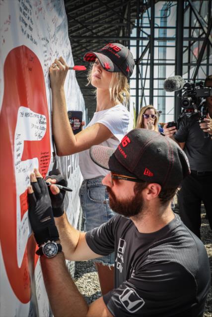 James Hinchcliffe and his fiancÃ©e, Becky, sign the #GetWellWickens banner during the autograph session at Gateway Motorsports Park -- Photo by: Shawn Gritzmacher