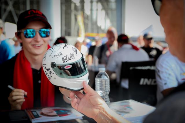 Zach Veach signs a mini-helmet during the autograph session at Gateway Motorsports Park -- Photo by: Shawn Gritzmacher