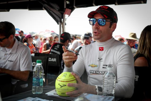Simon Pagenaud signs a mini-helmet during the autograph session at Gateway Motorsports Park -- Photo by: Shawn Gritzmacher
