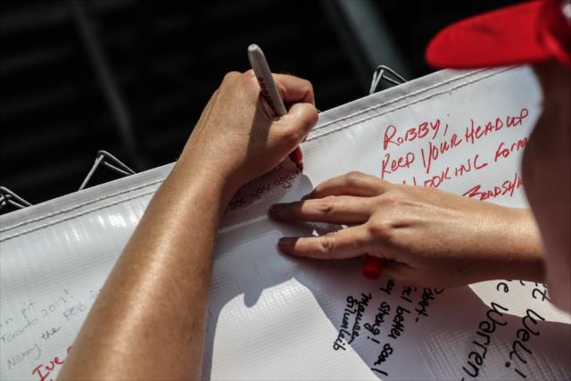 A fan signs the #GetWellWickens banner for Robert Wickens during the autograph session at Gateway Motorsports Park -- Photo by: Shawn Gritzmacher