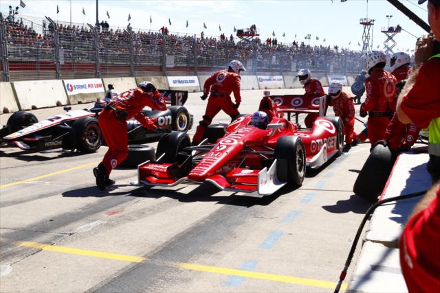 Scott Dixon finishes up a pit stop as Will Power roars by during Race 2 of the Shell and Pennzoil Grand Prix of Houston -- Photo by: Bret Kelley