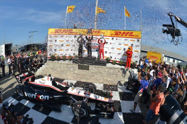 The confetti flies as Will Power, Juan Pablo Montoya, and Tony Kanaan raise their trophies in Victory Lane -- Photo by: Chris Owens