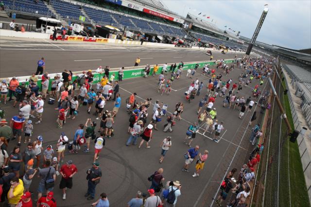 Fans walk the frontstretch during the post-race track invasion at the Indianapolis Motor Speedway -- Photo by: Joe Skibinski