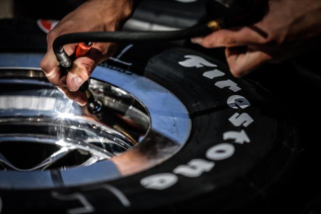 Crew member checks a Firestone Firehawk tire -- Photo by: Shawn Gritzmacher