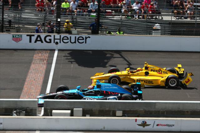 Carlos Munoz passes Helio Castroneves at the Yard of Bricks during the 100th Indianapolis 500 -- Photo by: Bret Kelley