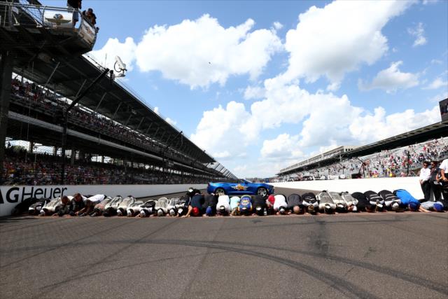 Alexander Rossi kisses the bricks with his team after winning the 100th Running of the Indianapolis 500 presented by PennGrade Motor Oil -- Photo by: Chris Jones
