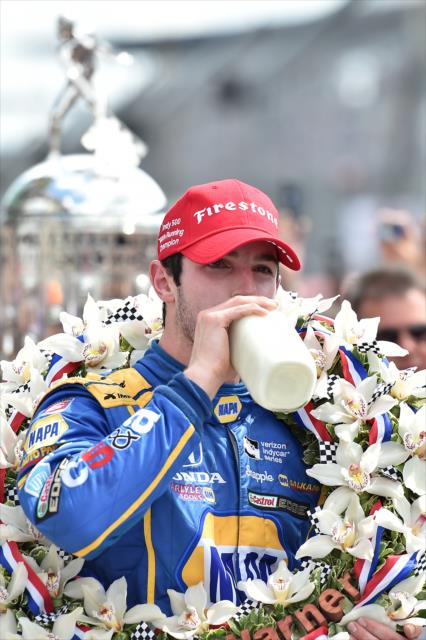 Alexander Rossi drinks a bottle of milk in victory circle after winning the 100th Running of the Indianapolis 500 presented by PennGrade Motor Oil -- Photo by: Chris Owens