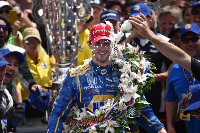 Alexander Rossi with a cold shower of milk in Victory Circle following his win in the 100th Indianapolis 500 -- Photo by: Dana Garrett