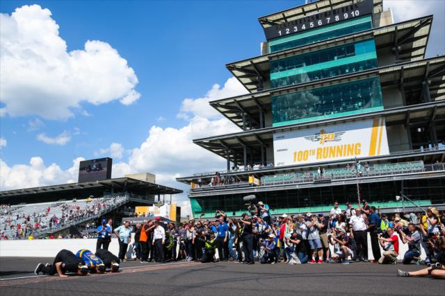 Alexander Rossi kisses the bricks with his team after winning the 100th Running of the Indianapolis 500 presented by PennGrade Motor Oil -- Photo by: David Yowe