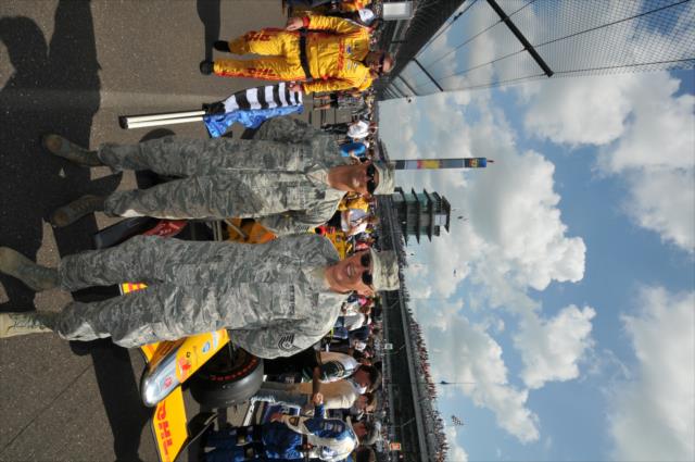 Military men in front of Ryan Hunter-Reay's car on the grid before the 100th running of the Indianapolis 500 presented by PennGrade Motor Oil -- Photo by: Eric McCombs
