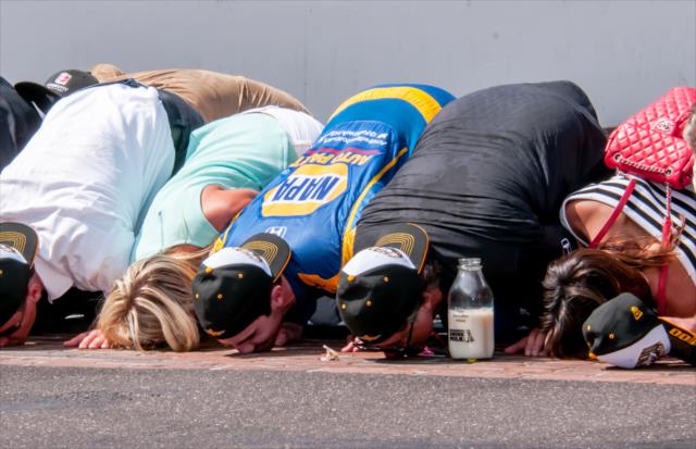 Alexander Rossi kisses the bricks with his team after winning the 100th Running of the Indianapolis 500 presented by PennGrade Motor Oil -- Photo by: Mike Finnegan