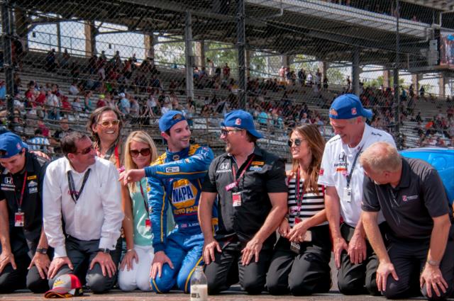 Alexander Rossi kisses the bricks with his team after winning the 100th Running of the Indianapolis 500 presented by PennGrade Motor Oil -- Photo by: Mike Finnegan