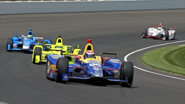 Alexander Rossi leaves a group through Turn 1 during the 100th Indianapolis 500 -- Photo by: Mike Harding