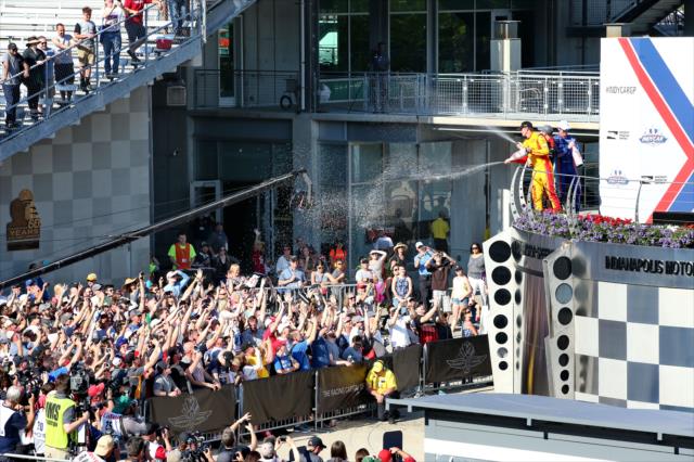 The champagne flies from Victory Circle to the fans below following the INDYCAR Grand Prix at the Indianapolis Motor Speedway -- Photo by: Chris Jones