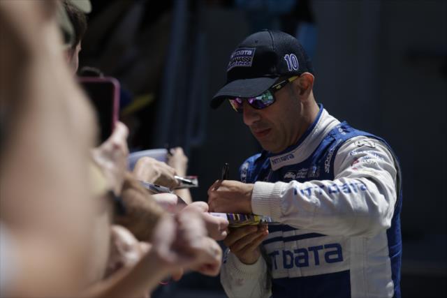 Tony Kanaan signs autographs before racing in the INDYCAR GP -- Photo by: Shawn Gritzmacher