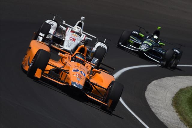 Fernando Alonso leads Helio Castroneves and Juan Pablo Montoya through Turn 1 during practice for the 101st Indianapolis 500 -- Photo by: Chris Owens