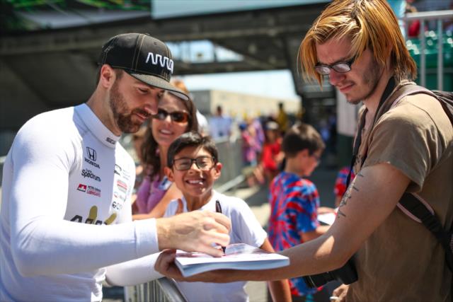 James Hinchcliffe signs an autograph along pit lane prior to practice for the 101st Indianapolis 500 -- Photo by: David Yowe