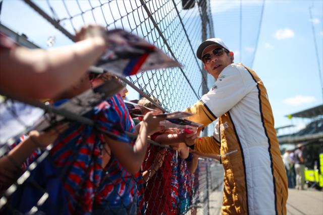 Helio Castroneves signs a few autographs along pit lane prior to practice for the 101st Indianapolis 500 -- Photo by: David Yowe