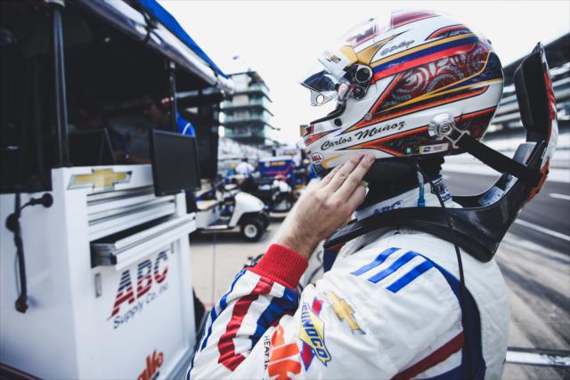 Carlos Munoz secures his helmet along pit lane prior to practice for the 101st Indianapolis 500 -- Photo by: Joe Skibinski