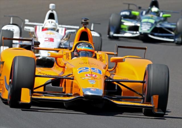 Fernando Alonso leads Helio Castroneves and Juan Pablo Montoya through Turn 1 during practice for the 101st Indianapolis 500 -- Photo by: Mike Harding