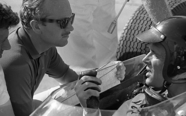 Dan Gurney chats with car engineer Colin Chapman during practice for the 1964 Indianapolis 500