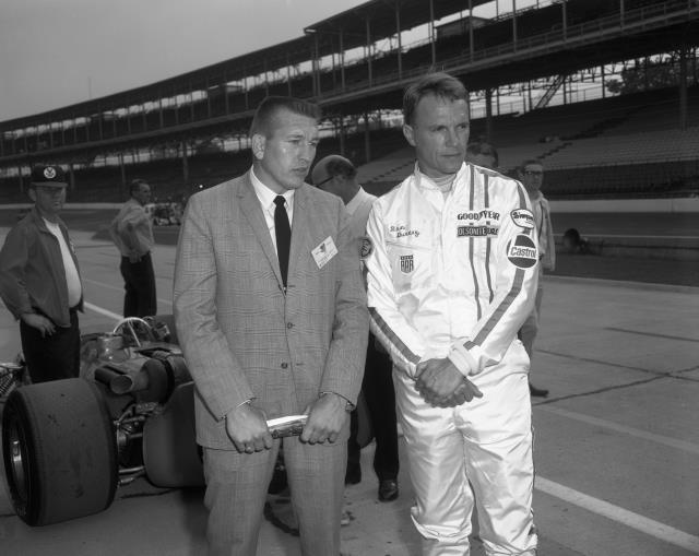 Dan Gurney chats with Baltimore Colt Johnny Unitas on pit lane prior to practice for the 1969 Indianapolis 500