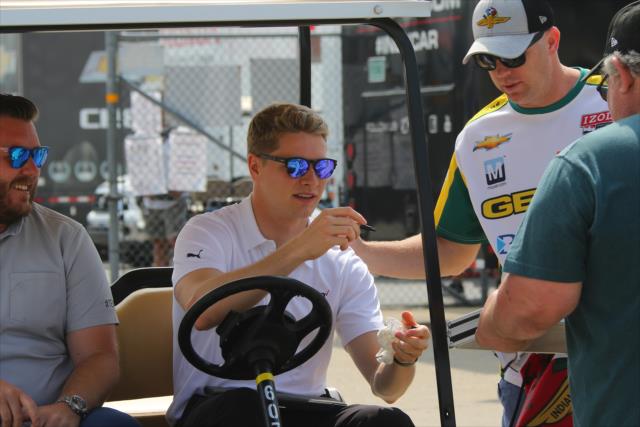 Josef Newgarden signs an autograph in Gasoline Alley prior to qualifications for the 102nd Indianapolis 500 at the Indianapolis Motor Speedway -- Photo by: Mike Harding
