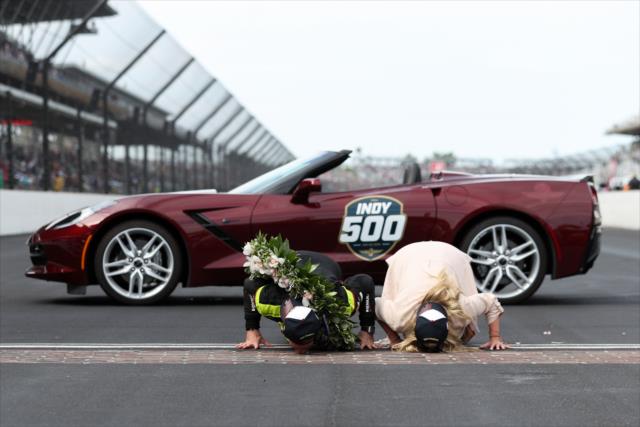 Simon Pagenaud and family kiss the bricks after the 103rd Indianapolis 500 presented by Gainbridge -- Photo by: Joe Skibinski