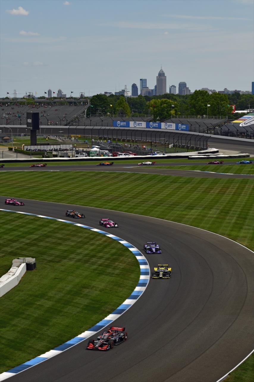 Will Power leads the field through Turn 14 and onto the historic main straightaway, with the city of Indianapolis in the background, during the Big Machine Spiked Coolers Grand Prix on Saturday, Aug. 14. -- Photo by: Walt Kuhn