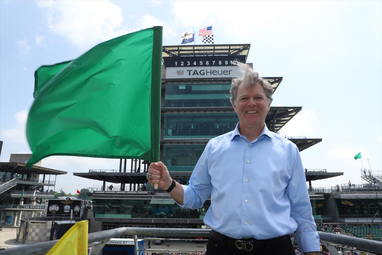 Eric Clark with NTT Data waves green flag - Indianapolis 500 Practice - By: Matt Fraver -- Photo by: Matt Fraver
