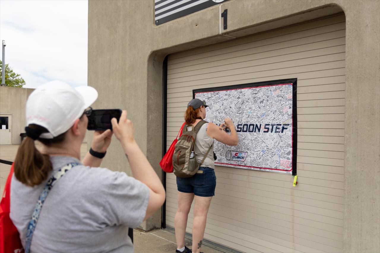 Fans sign a Get Well Soon sign for Stefan Wilson - Legends Day by Firestone - By: Travis Hinkle -- Photo by: Travis Hinkle
