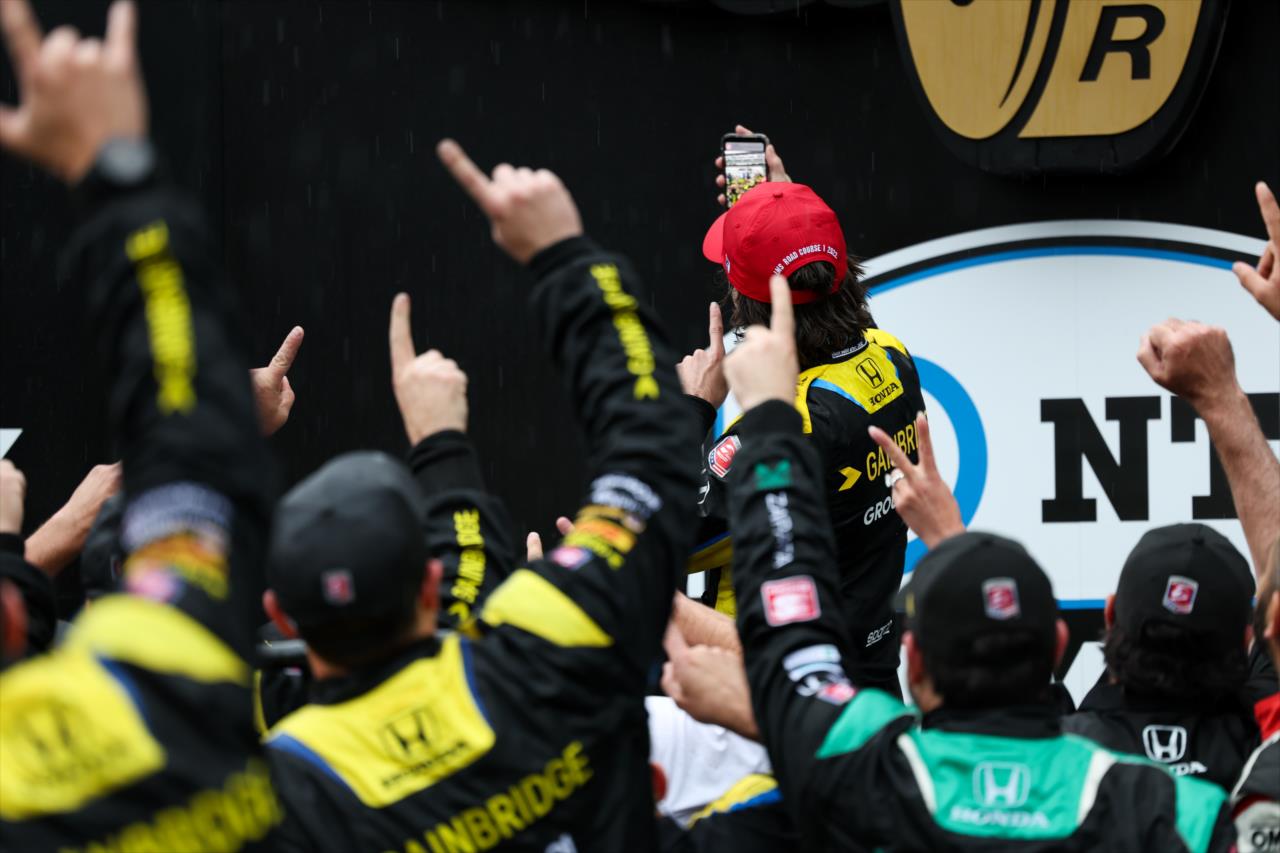 Colton Herta with a selfie on Victory Podium folowing his win in the 2022 GMR Grand Prix -- Photo by: Joe Skibinski