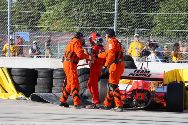 Team Penske driver Helio Castroneves is aided off the course after race incident. -- Photo by: Shawn Payne