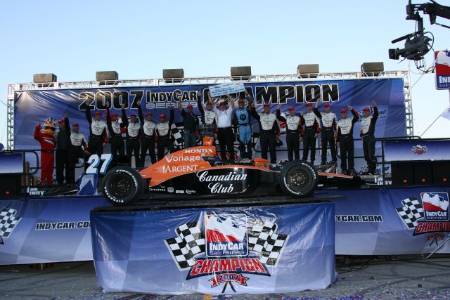 A champions podium with the winner car of Dario Franchitti and crew members. -- Photo by: Chris Jones