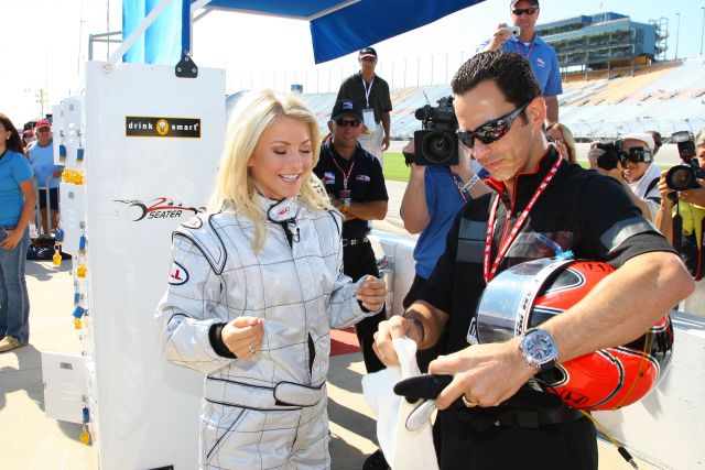 Helio Castroneves helps his dancing with the stars partner, Julianne Hough, prepare for her 2 seater ride at Chicagoland Speedway -- Photo by: Ron McQueeney
